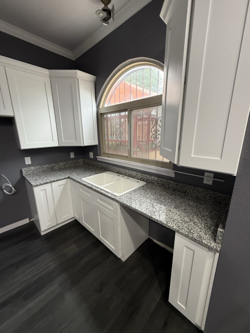 White shaker kitchen with speckled granite countertops