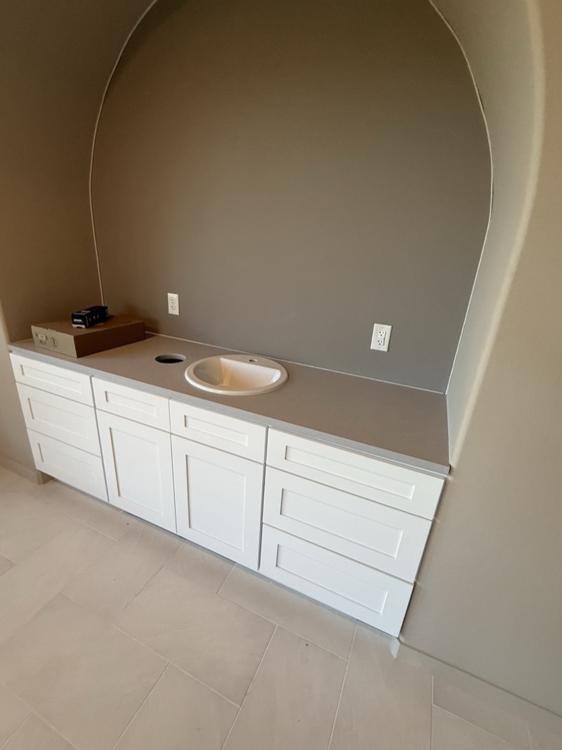 White shaker bathroom vanity with a gray countertop