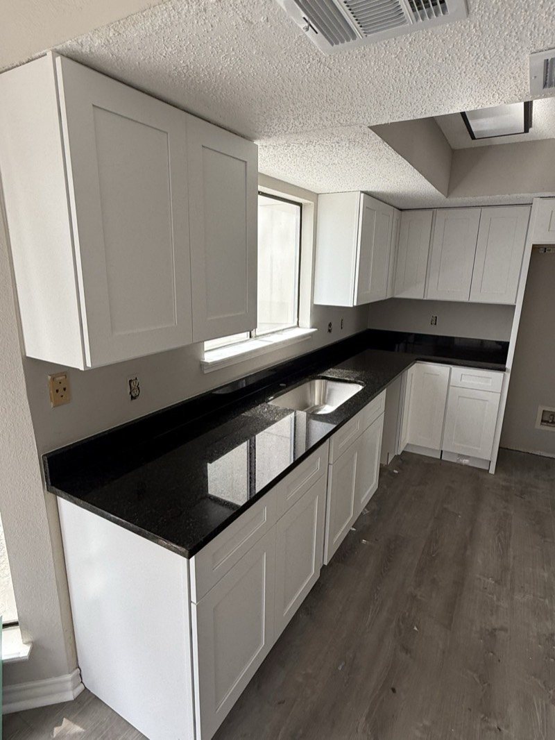 White cabinets with black granite countertops