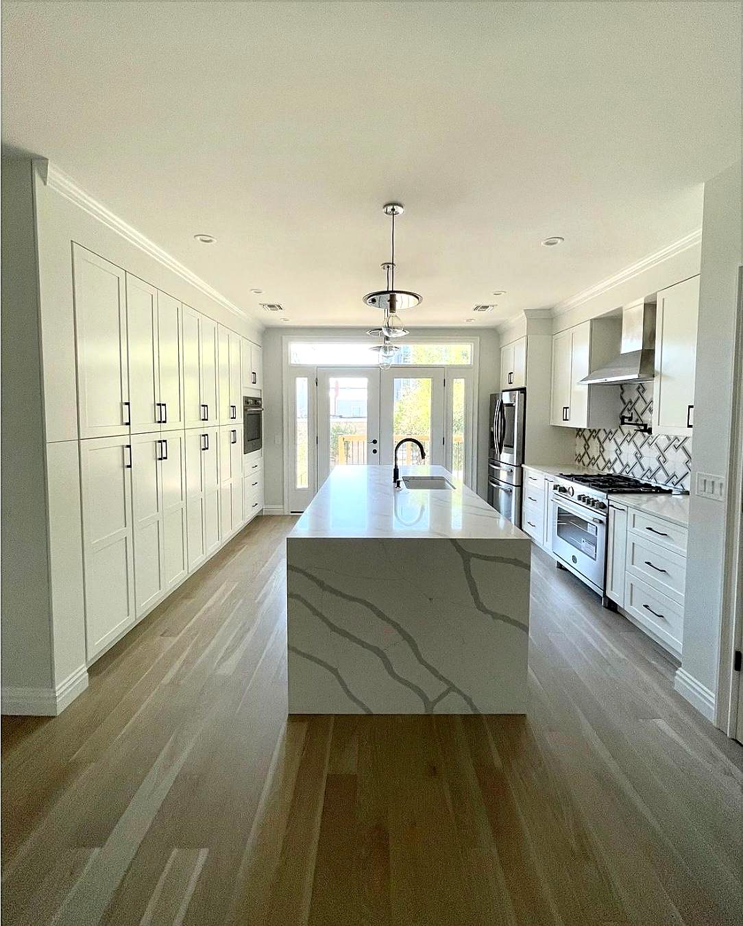 White galley kitchen with a waterfall island in San Antonio