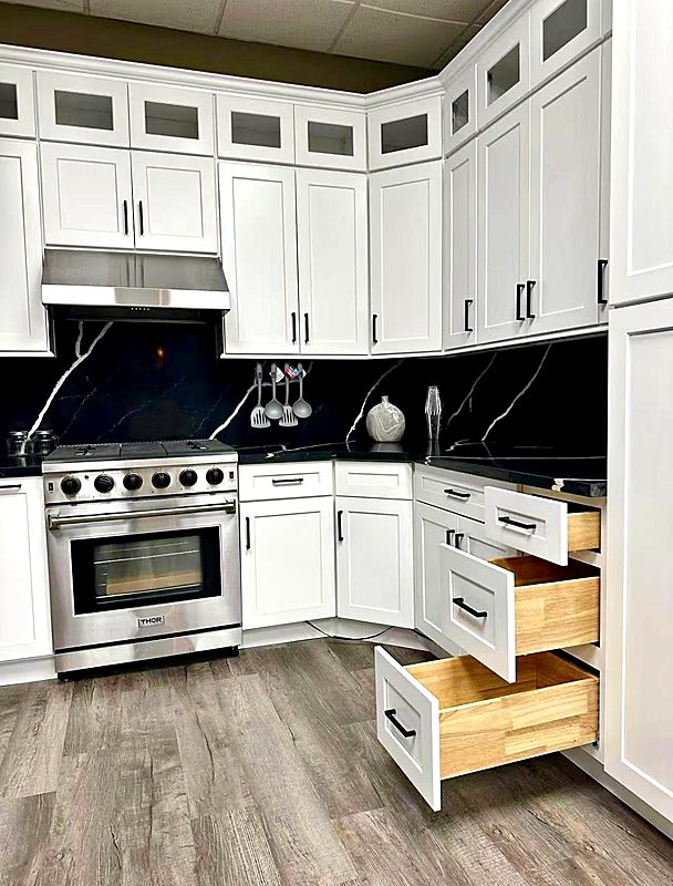 White kitchen cabinets with soft-close drawers beside a pro range