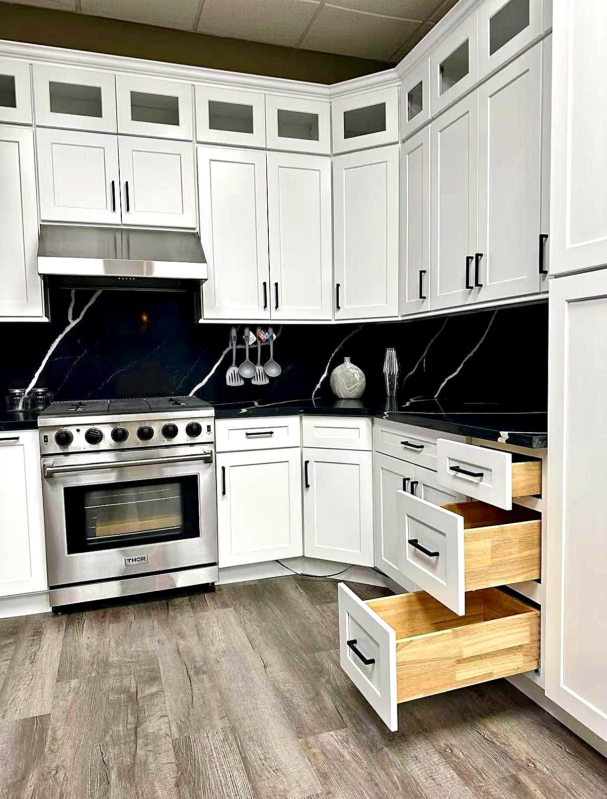 Gabinetes de cocina blancos con cajones de cierre suave junto a una estufa profesional